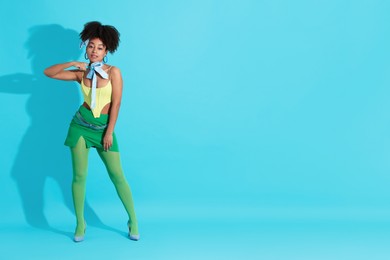 Photo of Fashionable portrait of beautiful Brazilian woman in stylish outfit on light blue background. Space for text