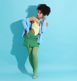Photo of Fashionable portrait of beautiful Brazilian woman in stylish outfit on light blue background