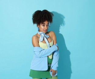 Photo of Fashionable portrait of beautiful Brazilian woman in stylish outfit on light blue background
