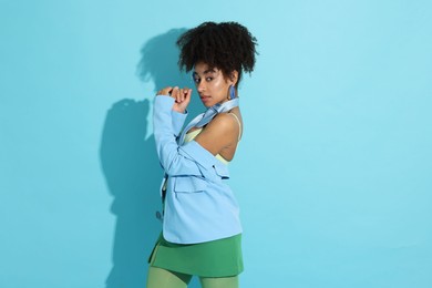 Photo of Fashionable portrait of beautiful Brazilian woman in stylish outfit on light blue background