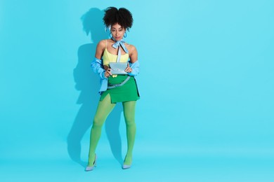Photo of Fashionable portrait of beautiful Brazilian woman in stylish outfit on light blue background. Space for text