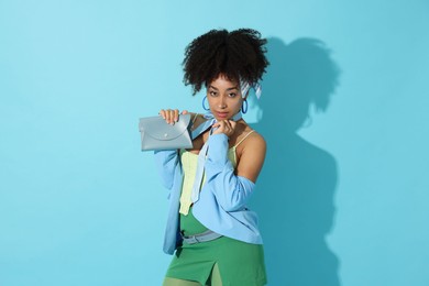 Photo of Fashionable portrait of beautiful Brazilian woman in stylish outfit on light blue background