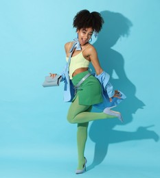 Photo of Fashionable portrait of beautiful Brazilian woman in stylish outfit on light blue background