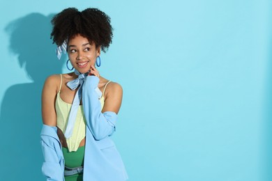 Photo of Fashionable portrait of beautiful Brazilian woman in stylish outfit on light blue background. Space for text