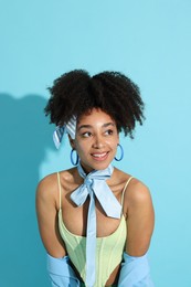 Photo of Fashionable portrait of beautiful Brazilian woman in stylish outfit on light blue background