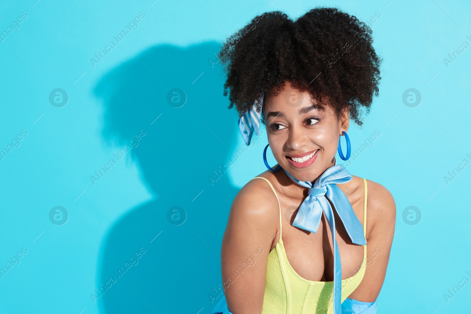 Fashionable portrait of beautiful Brazilian woman in stylish outfit on light blue background. Space for text Photo of Fashionable portrait of beautiful Brazilian woman in stylish outfit on light blue background. Space for text