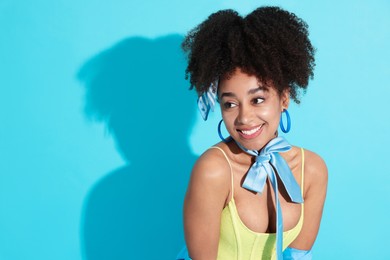 Photo of Fashionable portrait of beautiful Brazilian woman in stylish outfit on light blue background. Space for text