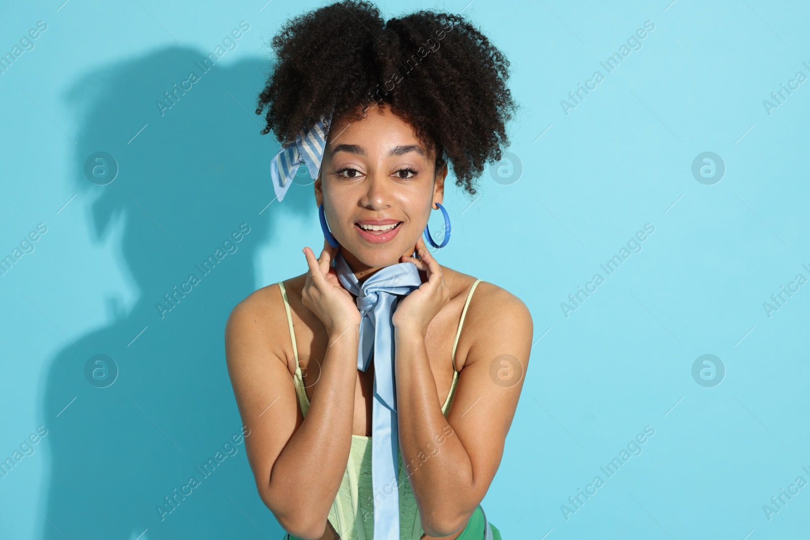 Fashionable portrait of beautiful Brazilian woman in stylish outfit on light blue background Photo of Fashionable portrait of beautiful Brazilian woman in stylish outfit on light blue background