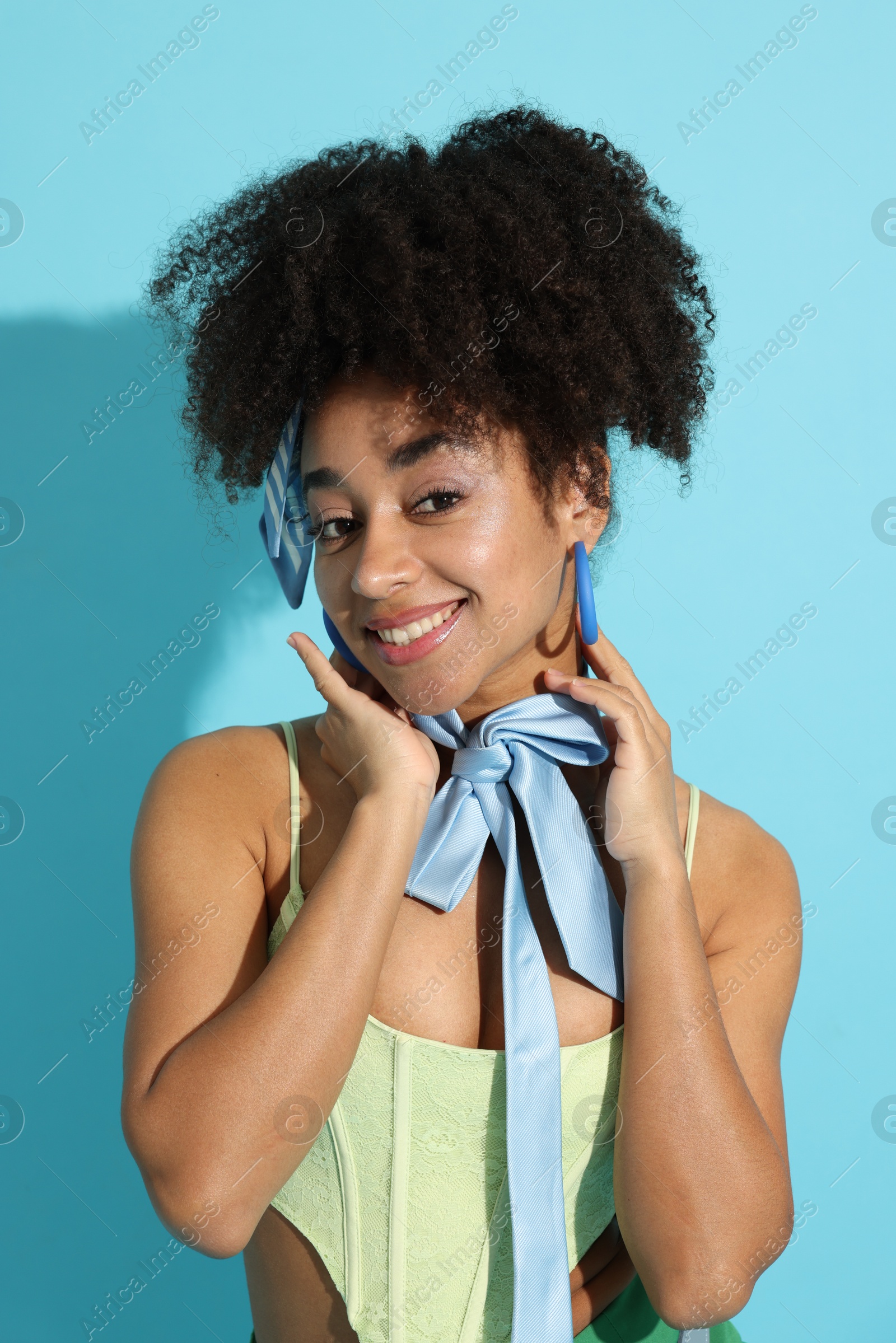 Photo of Fashionable portrait of beautiful Brazilian woman in stylish outfit on light blue background