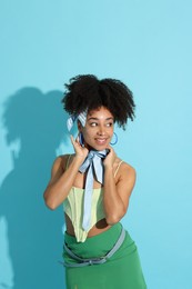 Photo of Fashionable portrait of beautiful Brazilian woman in stylish outfit on light blue background