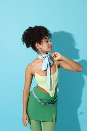 Photo of Fashionable portrait of beautiful Brazilian woman in stylish outfit on light blue background
