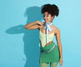 Photo of Fashionable portrait of beautiful Brazilian woman in stylish outfit on light blue background