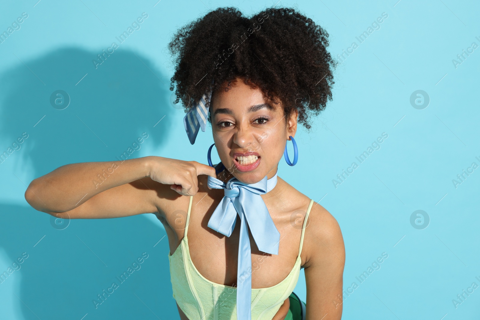 Fashionable portrait of beautiful Brazilian woman in stylish outfit on light blue background Photo of Fashionable portrait of beautiful Brazilian woman in stylish outfit on light blue background