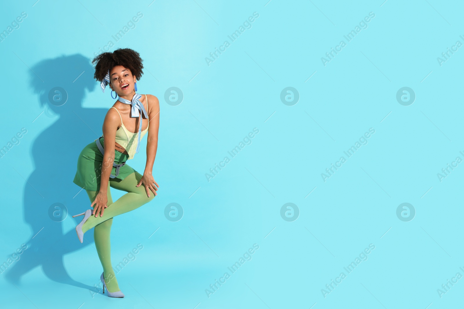 Fashionable portrait of beautiful Brazilian woman in stylish outfit on light blue background. Space for text Photo of Fashionable portrait of beautiful Brazilian woman in stylish outfit on light blue background. Space for text