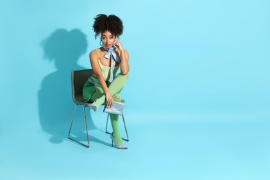 Photo of Fashionable portrait of beautiful Brazilian woman in stylish outfit on light blue background. Space for text