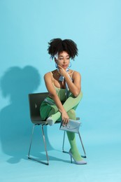 Photo of Fashionable portrait of beautiful Brazilian woman in stylish outfit on light blue background