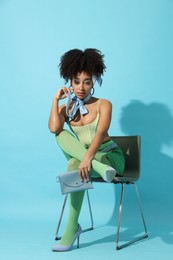 Photo of Fashionable portrait of beautiful Brazilian woman in stylish outfit on light blue background