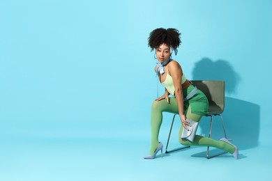 Photo of Fashionable portrait of beautiful Brazilian woman in stylish outfit on light blue background. Space for text