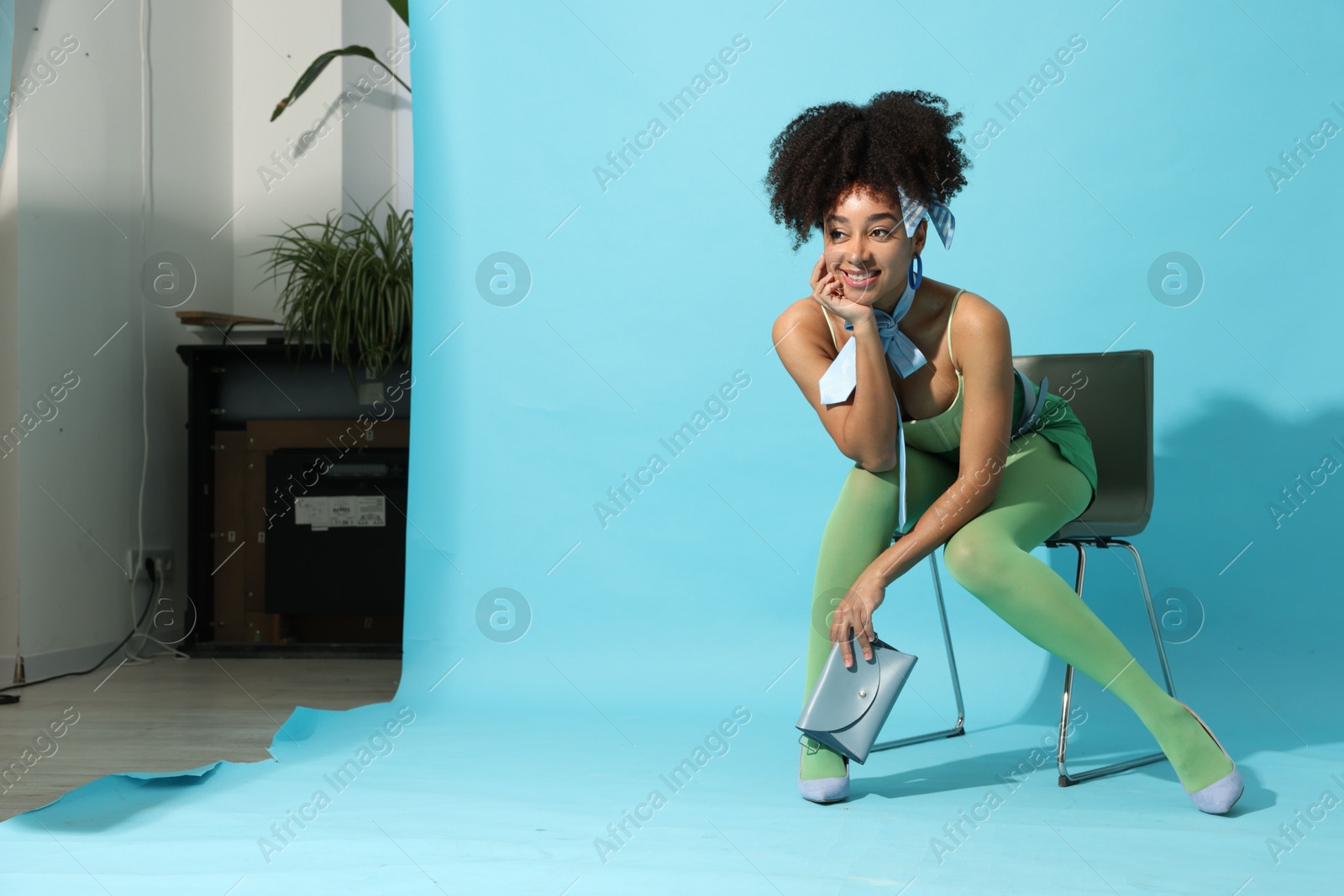 Fashionable portrait of beautiful Brazilian woman in stylish outfit on light blue background. Space for text Photo of Fashionable portrait of beautiful Brazilian woman in stylish outfit on light blue background. Space for text