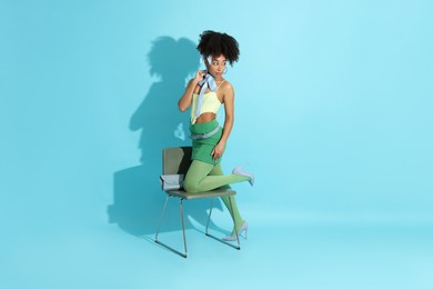 Photo of Fashionable portrait of beautiful Brazilian woman in stylish outfit on light blue background