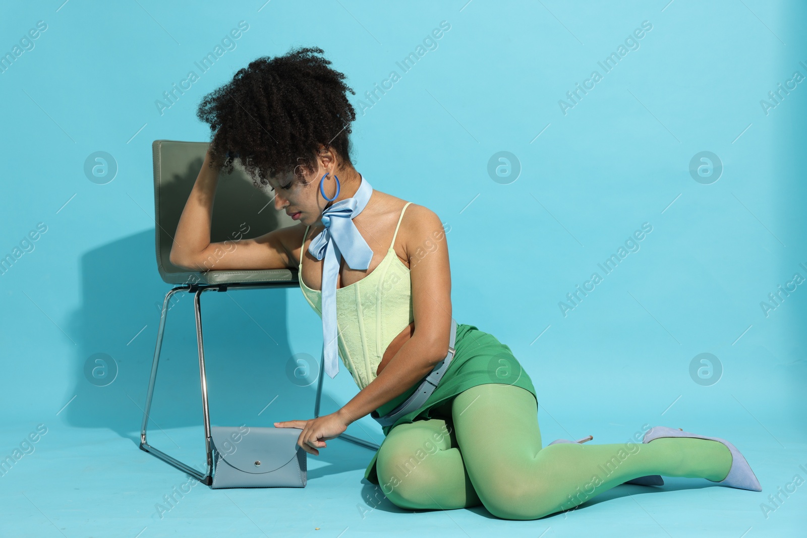 Fashionable portrait of beautiful Brazilian woman in stylish outfit on light blue background Photo of Fashionable portrait of beautiful Brazilian woman in stylish outfit on light blue background