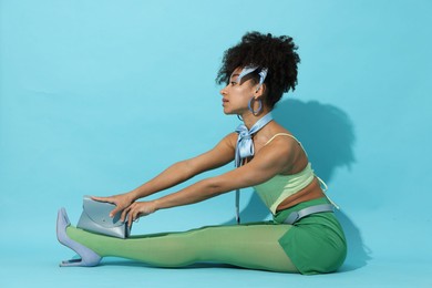 Photo of Fashionable portrait of beautiful Brazilian woman in stylish outfit on light blue background