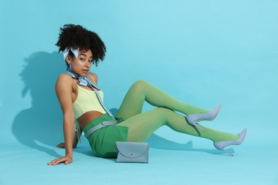 Photo of Fashionable portrait of beautiful Brazilian woman in stylish outfit on light blue background