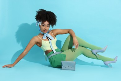 Photo of Fashionable portrait of beautiful Brazilian woman in stylish outfit on light blue background