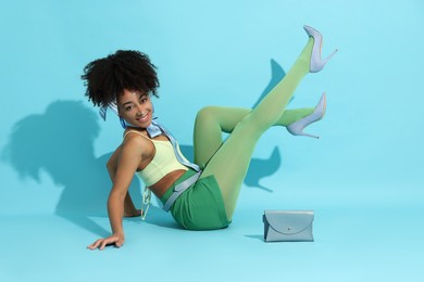 Photo of Fashionable portrait of beautiful Brazilian woman in stylish outfit on light blue background