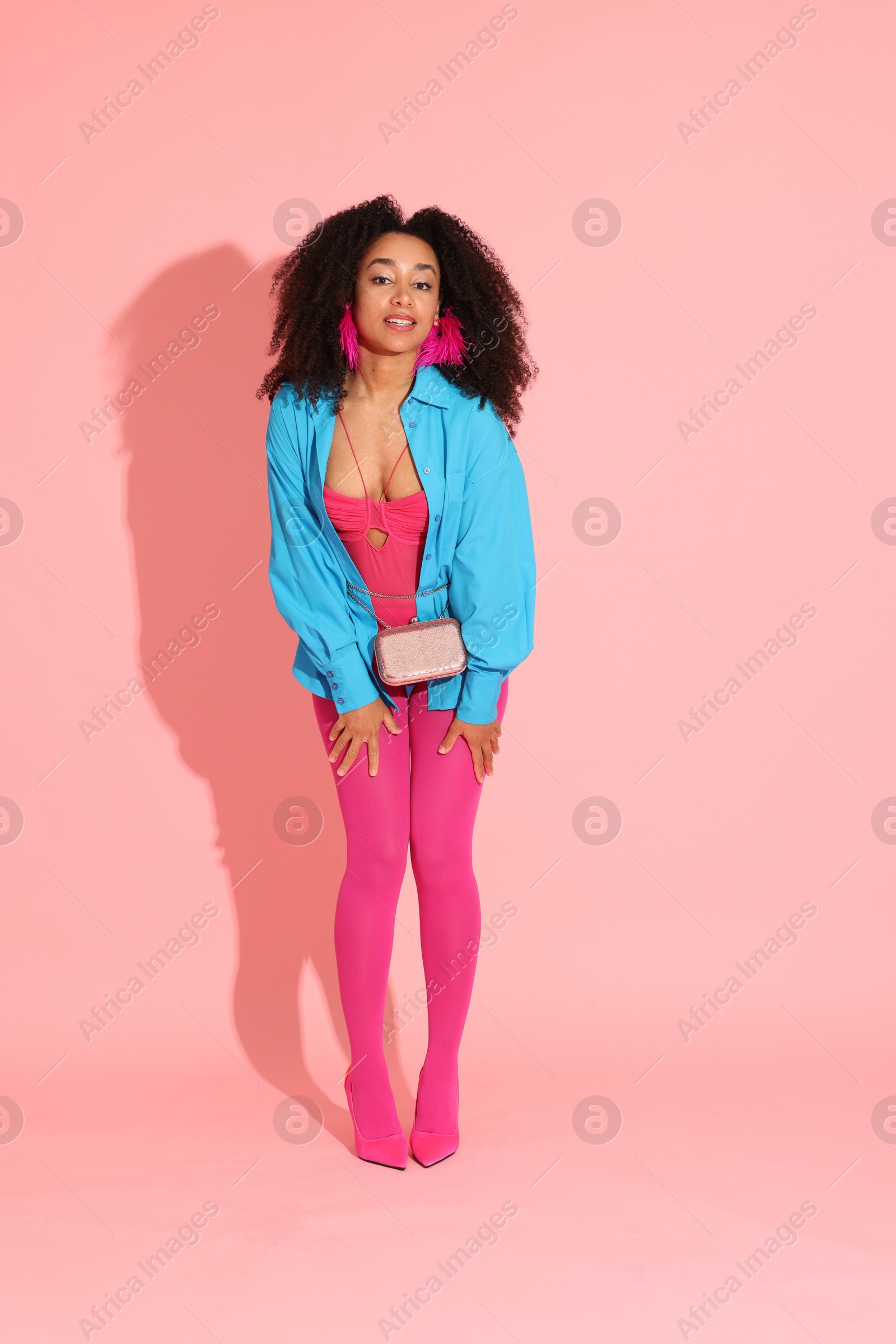 Fashionable portrait of beautiful Brazilian woman in stylish outfit on pink background Photo of Fashionable portrait of beautiful Brazilian woman in stylish outfit on pink background