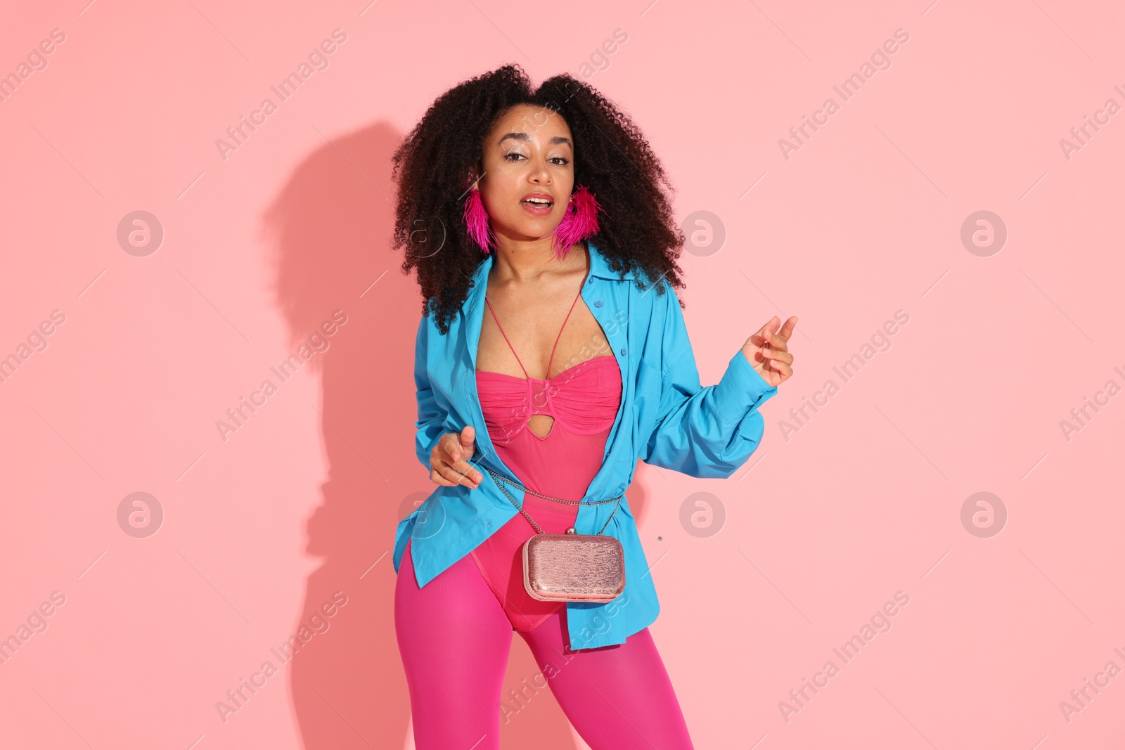 Fashionable portrait of beautiful Brazilian woman in stylish outfit on pink background Photo of Fashionable portrait of beautiful Brazilian woman in stylish outfit on pink background