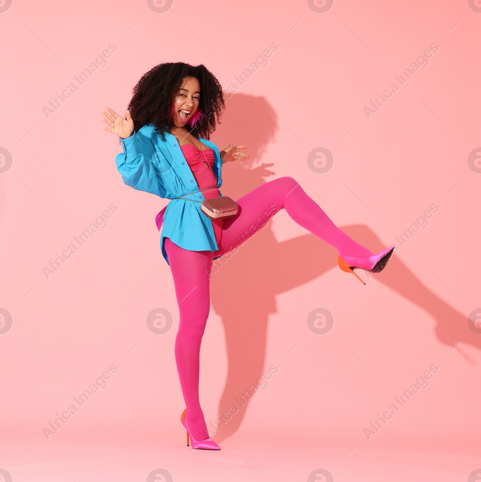 Fashionable portrait of beautiful Brazilian woman in stylish outfit on pink background Photo of Fashionable portrait of beautiful Brazilian woman in stylish outfit on pink background