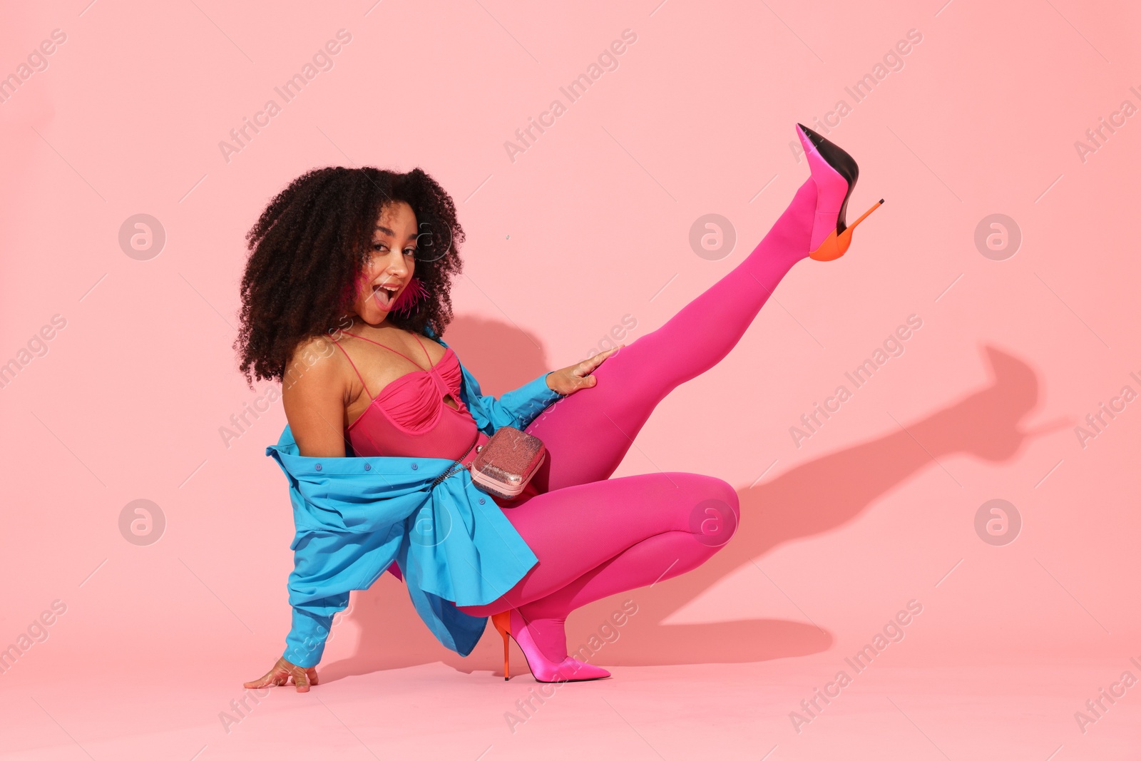 Photo of Fashionable portrait of beautiful Brazilian woman in stylish outfit on pink background