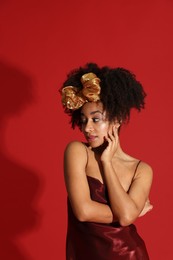 Photo of Fashionable portrait of beautiful Brazilian woman in stylish outfit on red background
