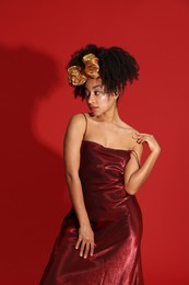 Photo of Fashionable portrait of beautiful Brazilian woman in stylish outfit on red background
