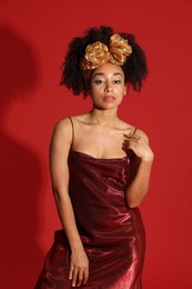 Photo of Fashionable portrait of beautiful Brazilian woman in stylish outfit on red background