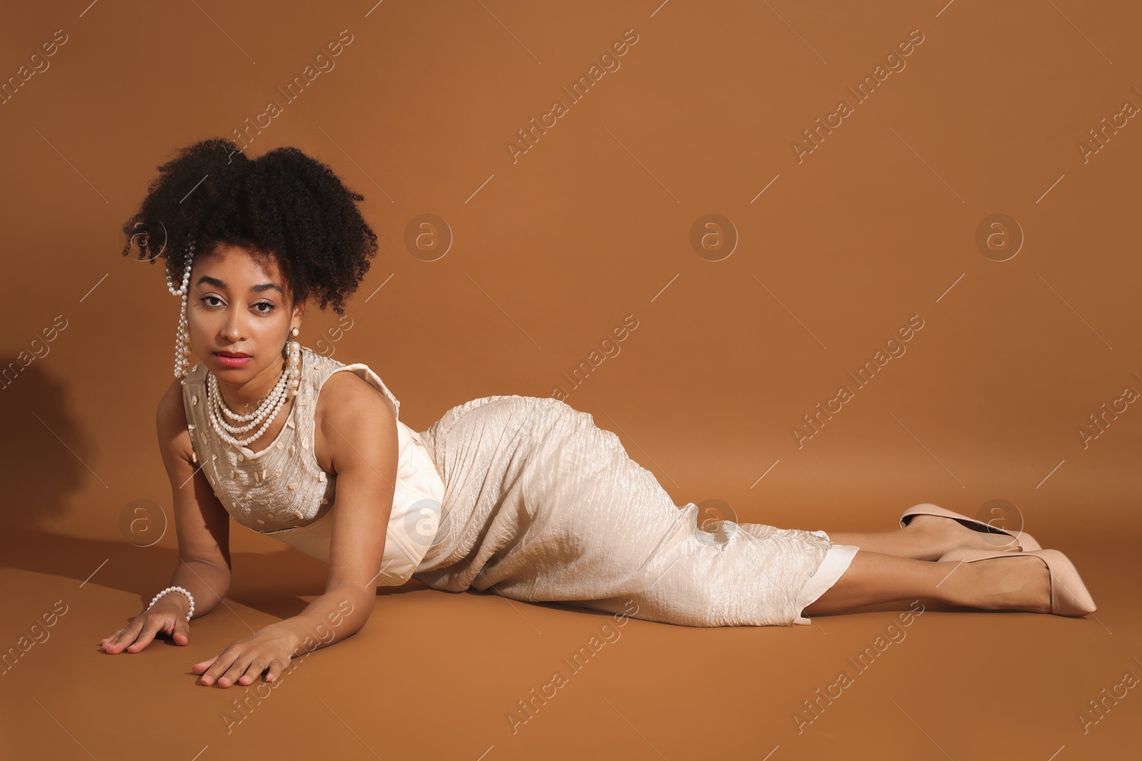 Fashionable portrait of beautiful Brazilian woman in stylish outfit on light brown background Photo of Fashionable portrait of beautiful Brazilian woman in stylish outfit on light brown background