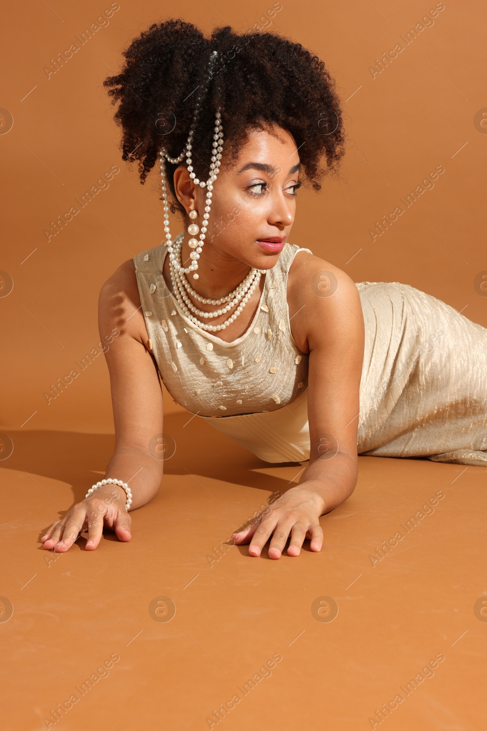 Fashionable portrait of beautiful Brazilian woman in stylish outfit on light brown background Photo of Fashionable portrait of beautiful Brazilian woman in stylish outfit on light brown background