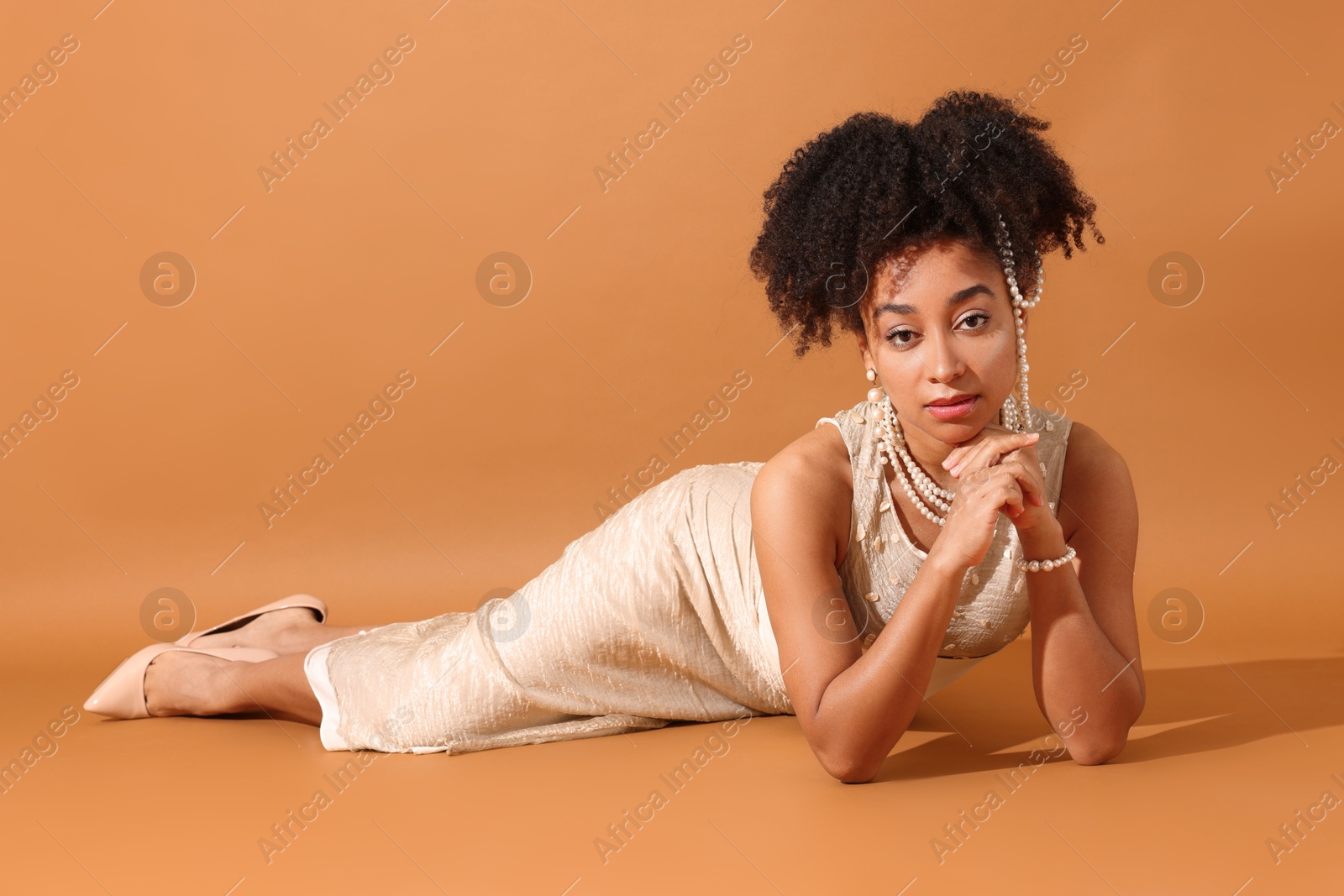 Fashionable portrait of beautiful Brazilian woman in stylish outfit on light brown background Photo of Fashionable portrait of beautiful Brazilian woman in stylish outfit on light brown background