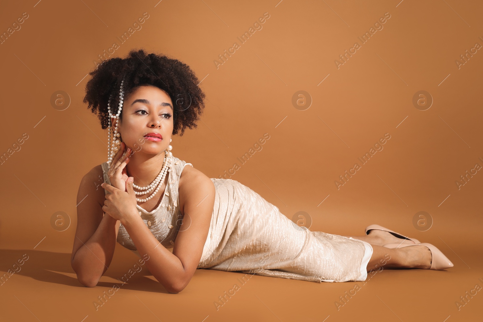 Fashionable portrait of beautiful Brazilian woman in stylish outfit on light brown background Photo of Fashionable portrait of beautiful Brazilian woman in stylish outfit on light brown background