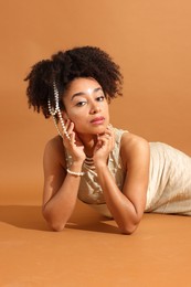 Photo of Fashionable portrait of beautiful Brazilian woman in stylish outfit on light brown background