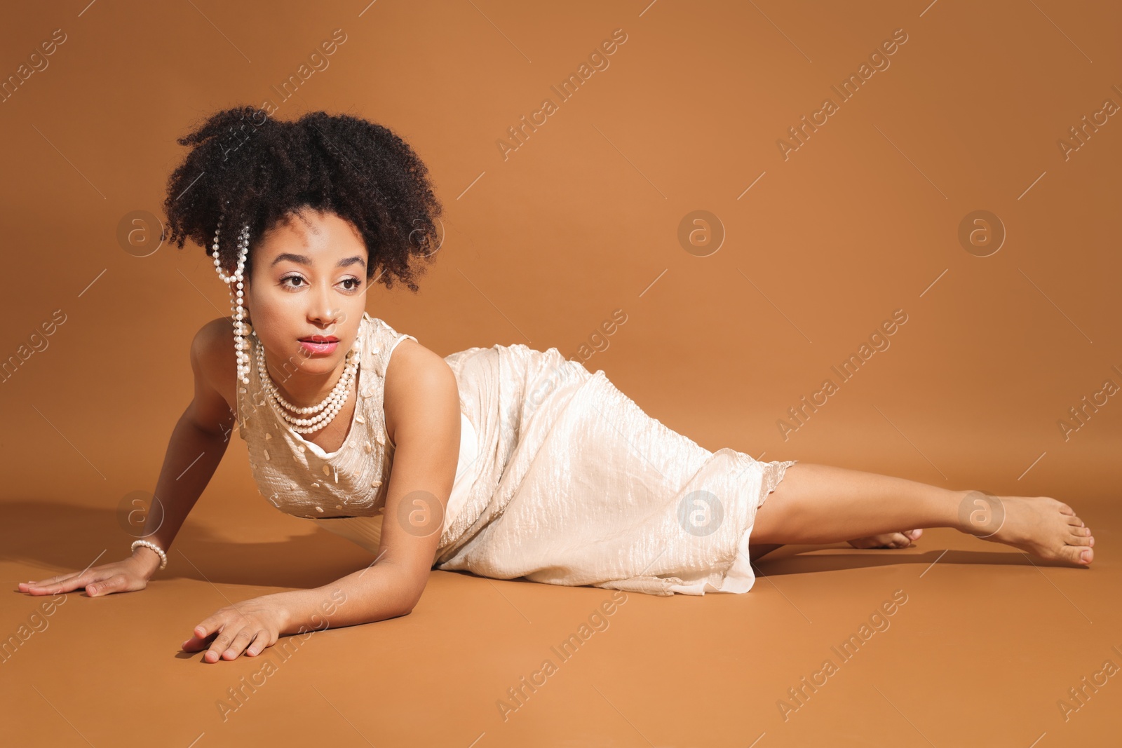 Photo of Fashionable portrait of beautiful Brazilian woman in stylish outfit on light brown background