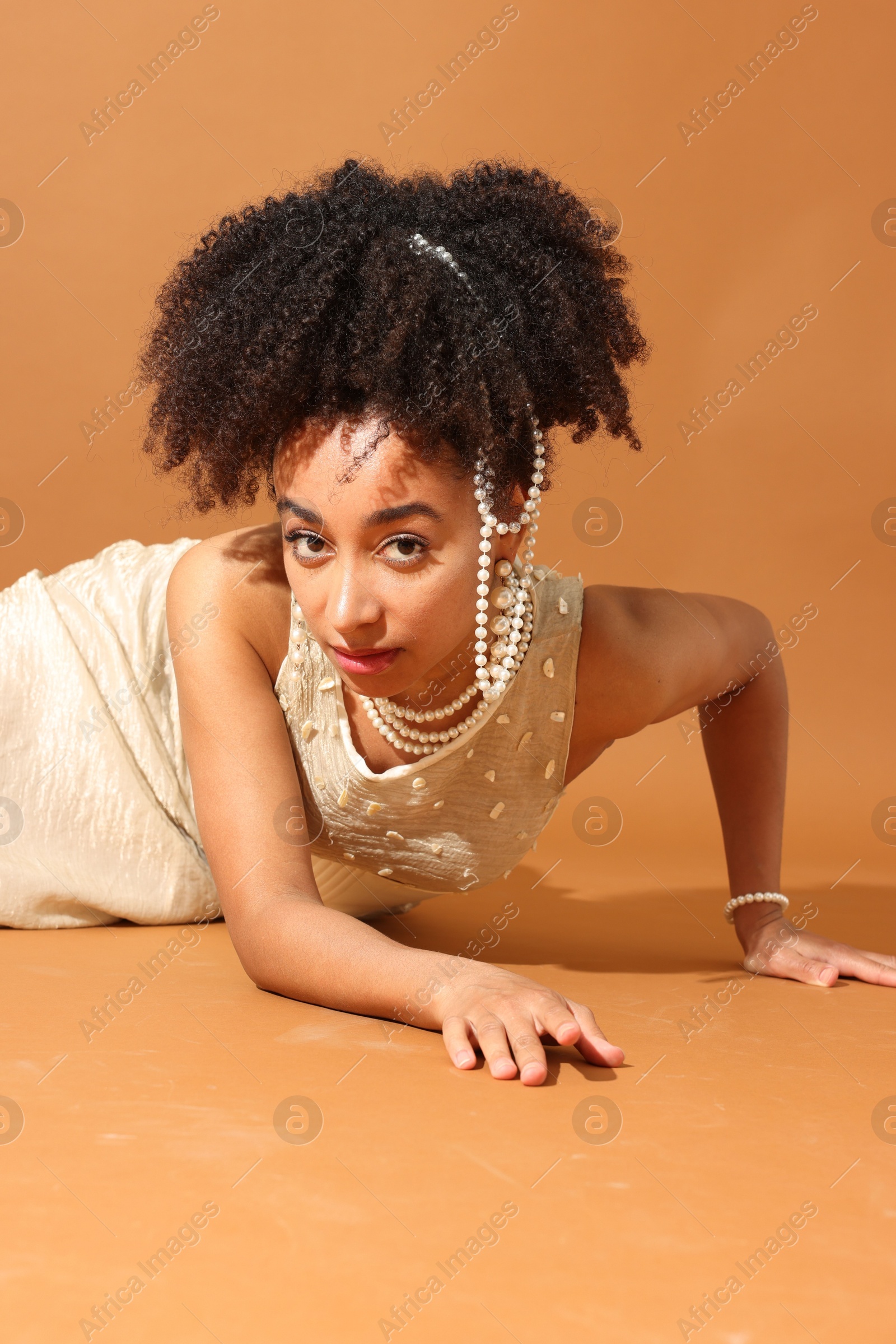 Photo of Fashionable portrait of beautiful Brazilian woman in stylish outfit on light brown background