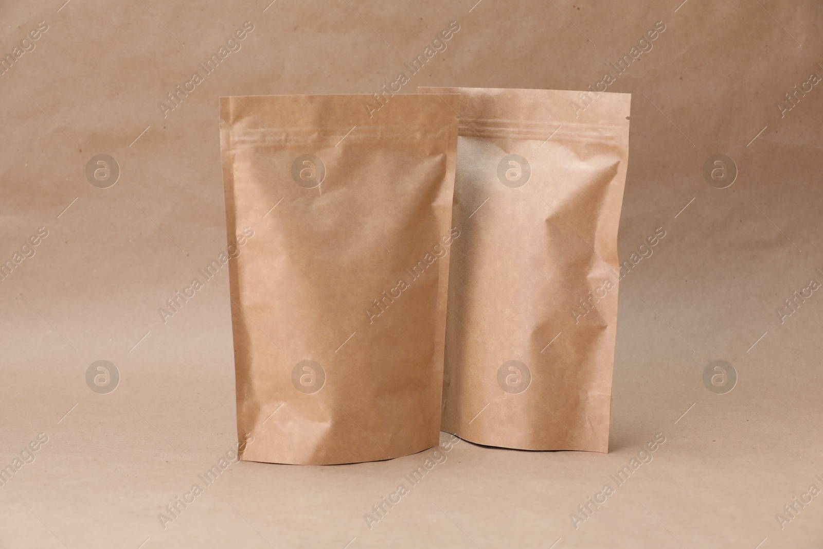 Zipper stand-up pouches on kraft paper background. Mockup for design Photo of Zipper stand-up pouches on kraft paper background. Mockup for design