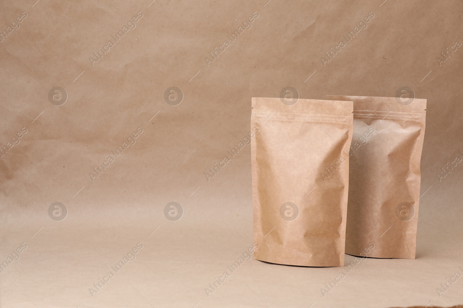 Zipper stand-up pouches on kraft paper background. Mockup for design Photo of Zipper stand-up pouches on kraft paper background. Mockup for design