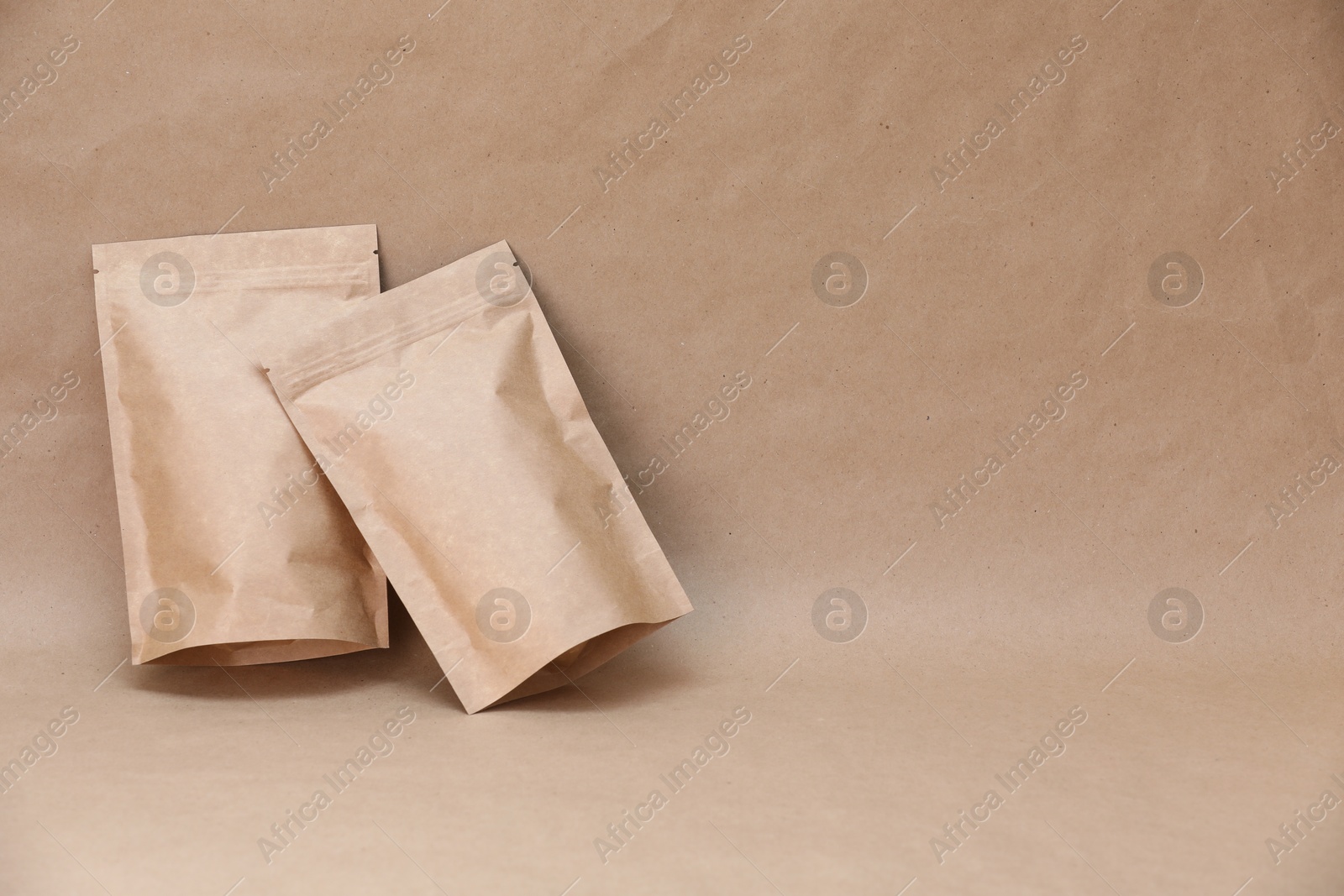 Zipper stand-up pouches on kraft paper background. Mockup for design Photo of Zipper stand-up pouches on kraft paper background. Mockup for design