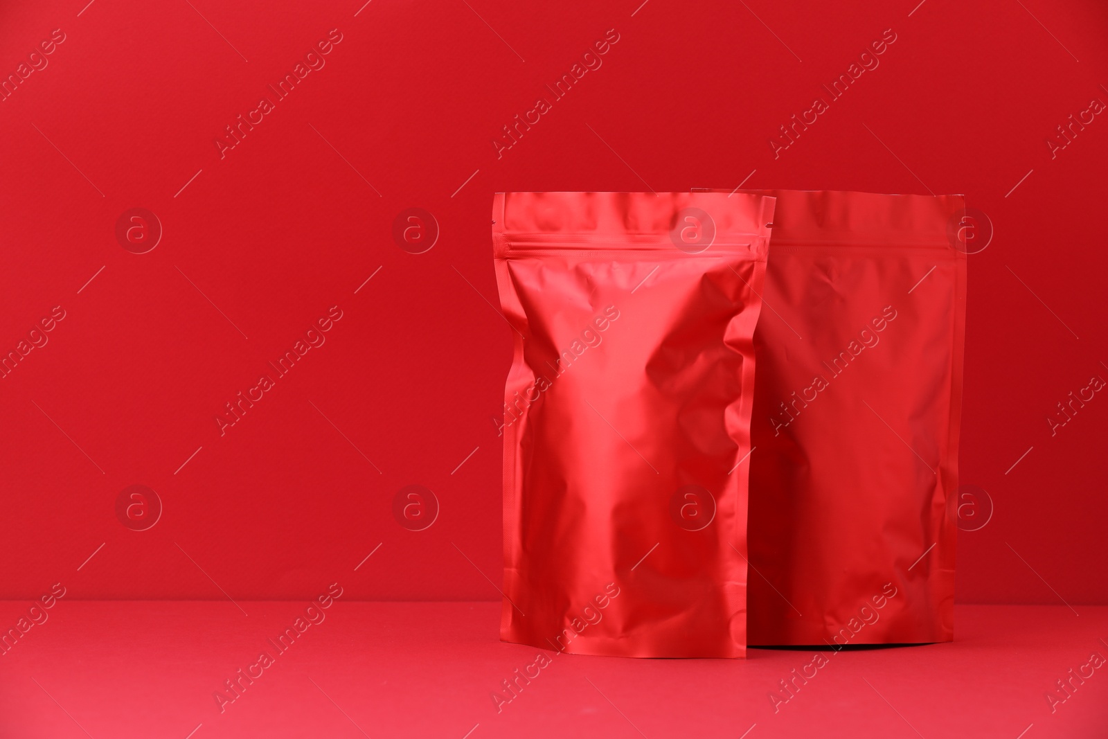 Zipper stand-up pouches on red background. Mockup for design Photo of Zipper stand-up pouches on red background. Mockup for design