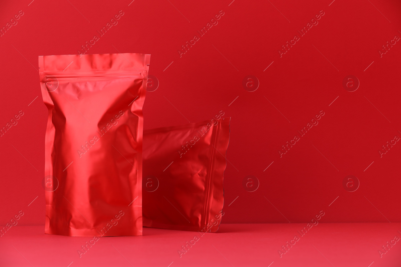 Zipper stand-up pouches on red background. Mockup for design Photo of Zipper stand-up pouches on red background. Mockup for design
