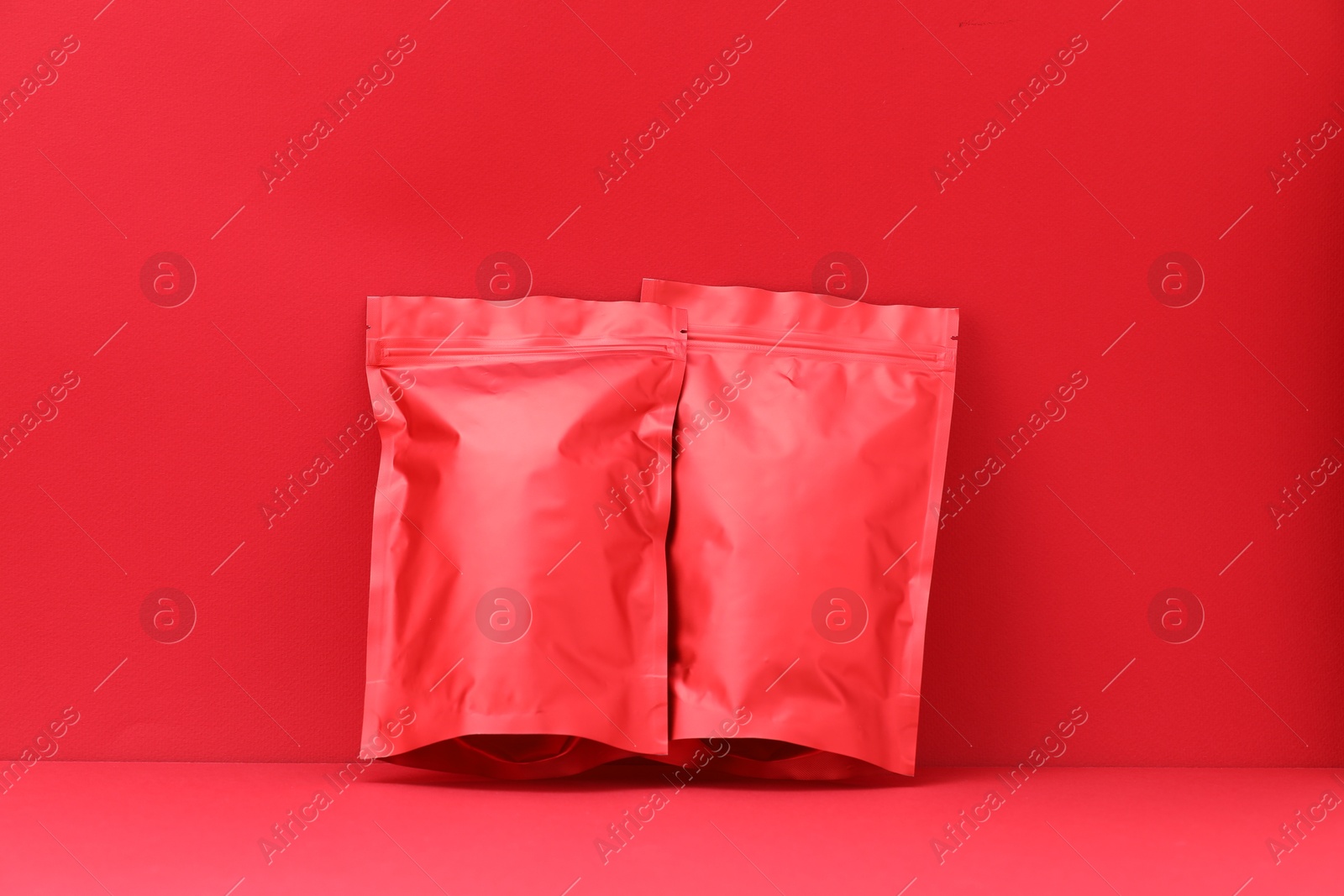 Zipper stand-up pouches on red background. Mockup for design Photo of Zipper stand-up pouches on red background. Mockup for design
