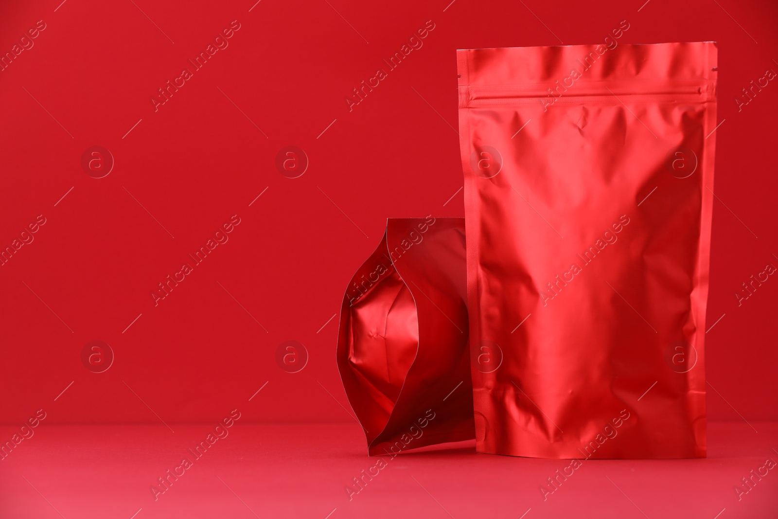 Zipper stand-up pouches on red background. Mockup for design Photo of Zipper stand-up pouches on red background. Mockup for design